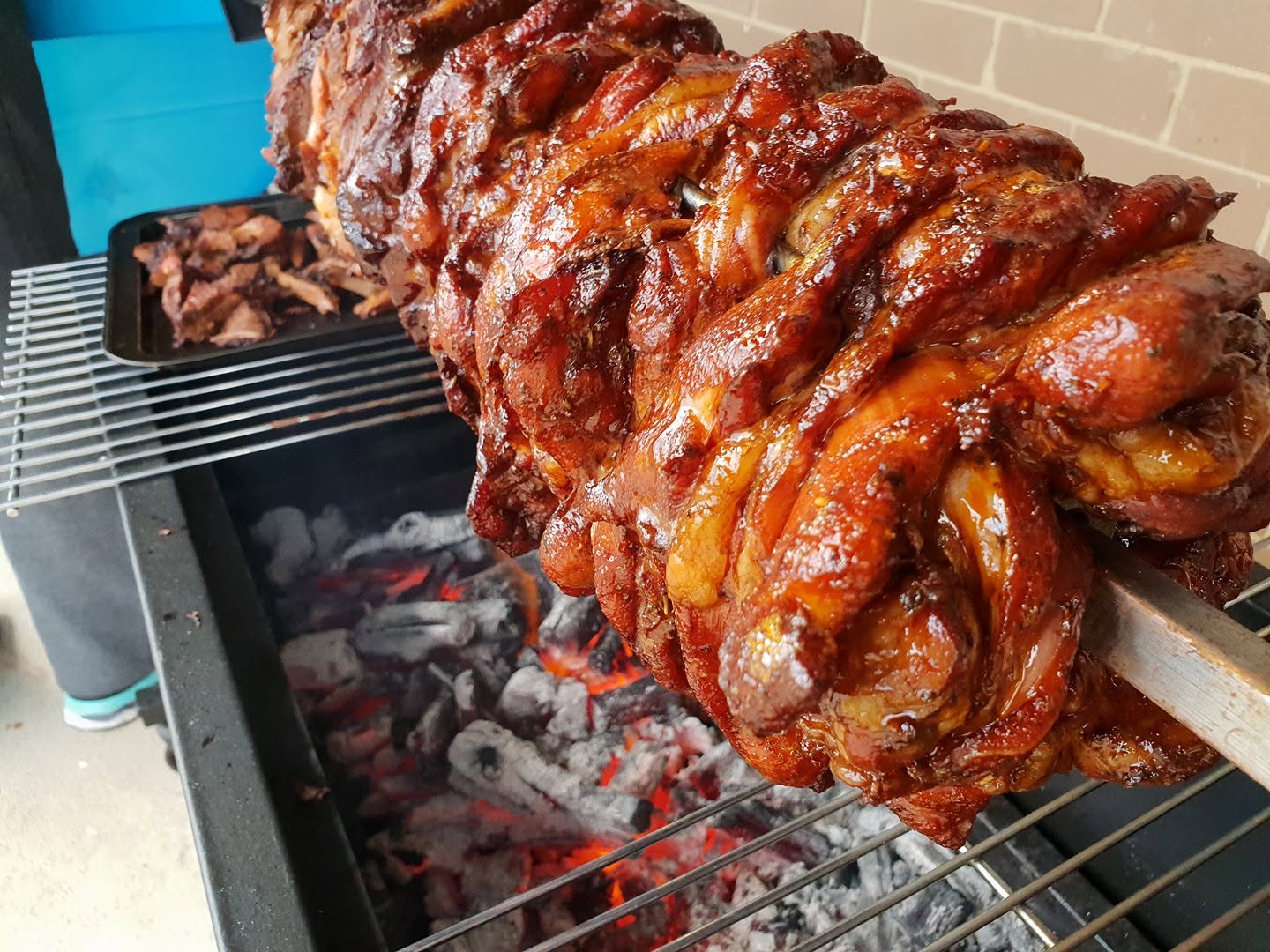 Freshly cooked glazed meat on a charcoal spit